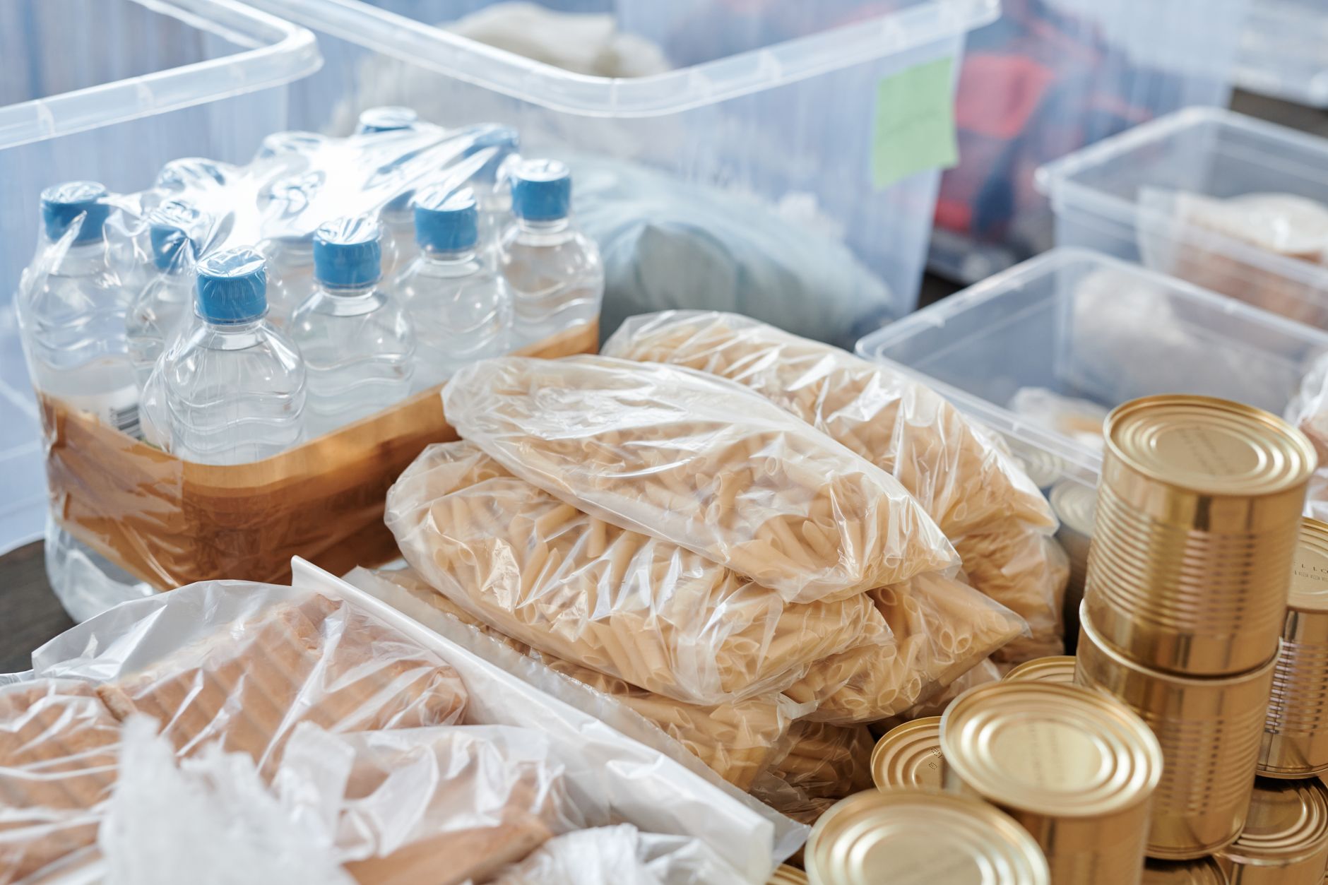 A well-organized emergency food pantry with canned goods, grains, and water jugs.